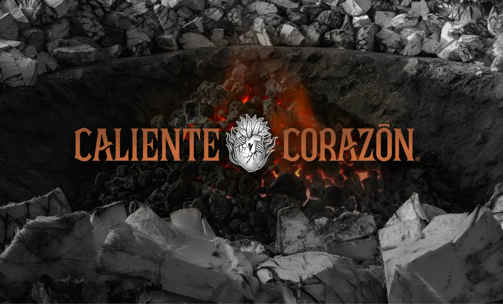 Identidad visual de Caliente Corazón aplicada sobre fotografía de brasas encendidas, con logotipo color cobre y corazón ilustrado.